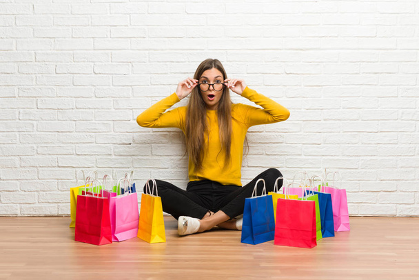 Young girl with lot of shopping bags with glasses and surprised - Photo, Image