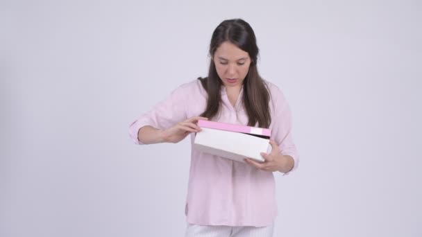 Young happy multi-ethnic businesswoman opening gift box and looking surprised - Imágenes, Vídeo