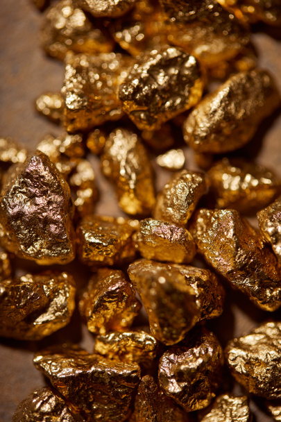 top view of golden stones on brown background - Fotografie, Obrázek
