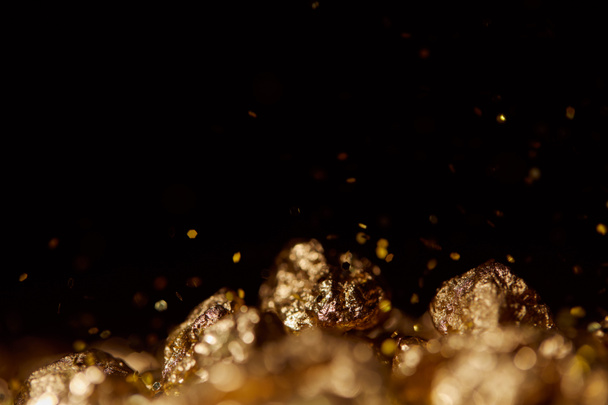 selective focus of golden stones with sparkling lights isolated on black - Φωτογραφία, εικόνα