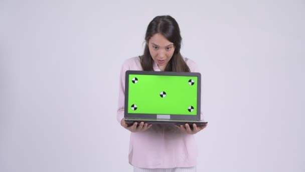 Young happy multi-ethnic businesswoman showing laptop and looking surprised - Кадри, відео