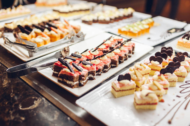 Assortment of fresh desserts displayed in hotel buffet. Variety of cakes in canteen ready for dinner. All inclusive - Φωτογραφία, εικόνα
