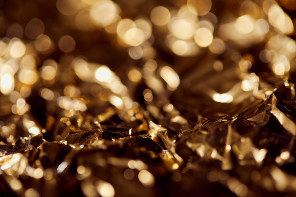 selrctive focus of foil with golden sparkling lights in shadows - Zdjęcie, obraz