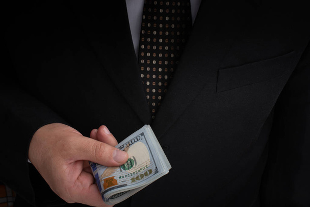 Бізнесмен, який тримає гроші в доларах США на білому фоні. - Фото, зображення