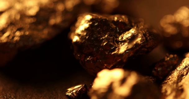 foco seletivo de pedras brilhantes em ouro em bruto sobre fundo texturizado
 - Filmagem, Vídeo