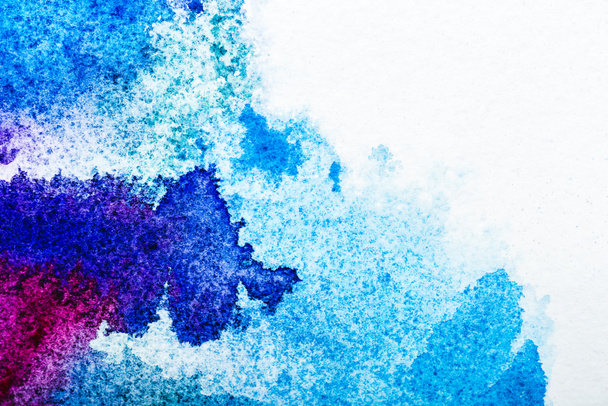 top view of blue and pink watercolor spills on white paper with copy space  - Фото, изображение
