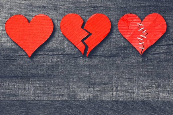 Tres corazones sanos / rotos / cosidos sobre fondo de madera con espacio para copiar. Día de San Valentín
 - Foto, Imagen