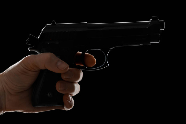 Male hand with pistol on dark background - Photo, Image