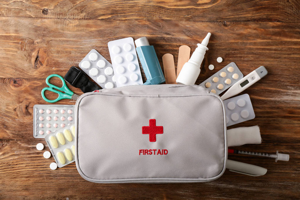First aid kit on wooden background - Photo, Image
