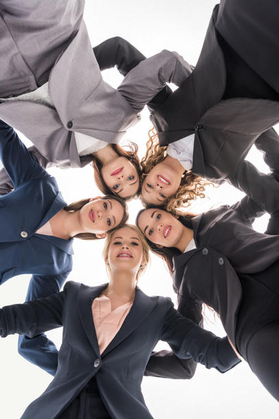 bottom view of cheerful businesswomen hugging isolated on grey - Φωτογραφία, εικόνα