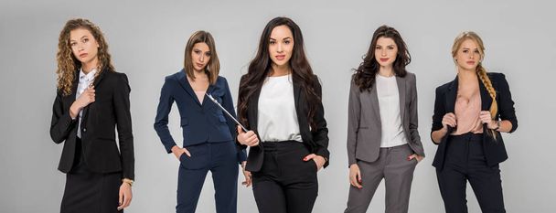 fiduciose giovani donne di successo in piedi con le mani in tasca isolate sul grigio
  - Foto, immagini