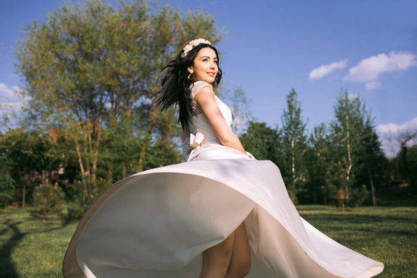 Gyönyörű menyasszony pózol a parkban, boldog barna. - Fotó, kép