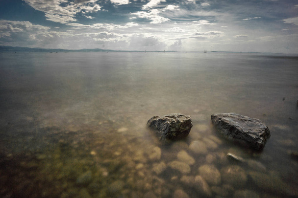 Germany Lake constance summertime shore rocks in water cloud - Photo, Image