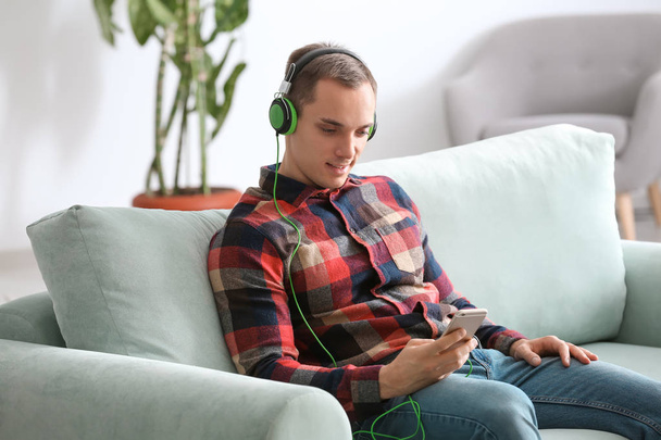 Handsome young man listening to music at home - Foto, afbeelding