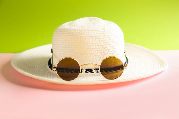 Óculos de sol elegantes com chapéu no fundo de cor - Foto, Imagem