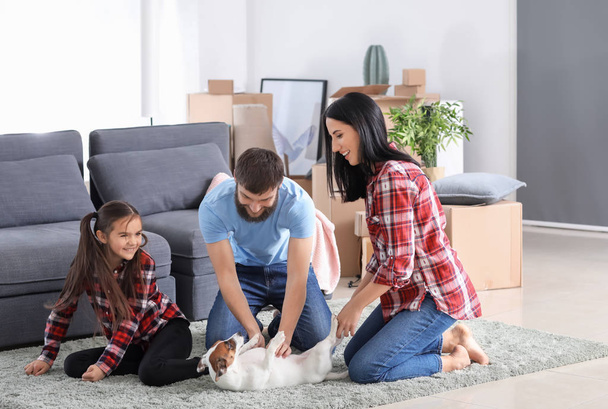 Familia jugando con el perro en su nueva casa
 - Foto, imagen