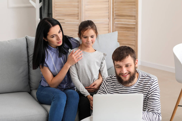 Happy family using laptop at home - Fotó, kép
