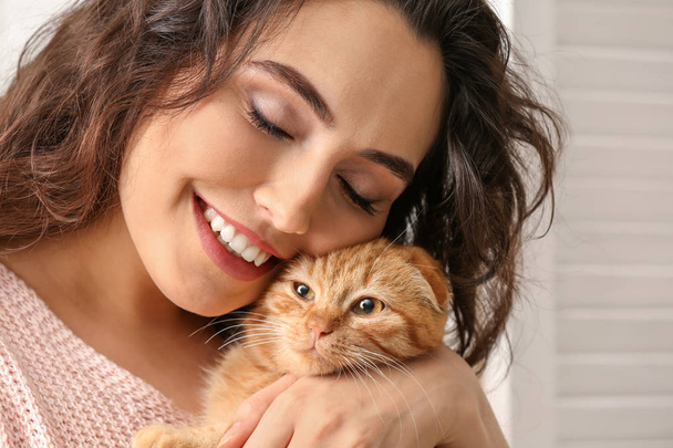 Young woman with cute funny cat at home - Fotoğraf, Görsel
