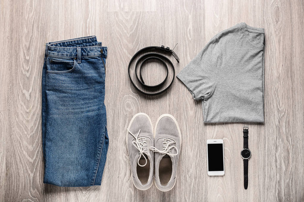 Стильная мужская одежда с аксессуарами и мобильным телефоном на деревянном фоне
 - Фото, изображение