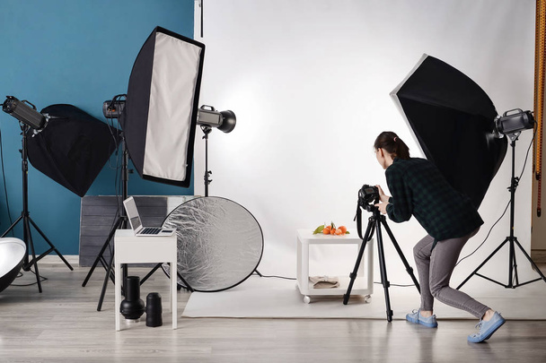 junge Frau fotografiert frische Mandarinen im professionellen Atelier - Foto, Bild
