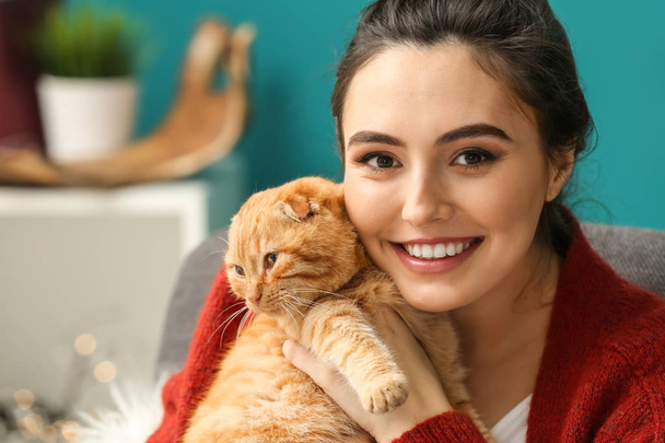 Young woman with cute funny cat at home - Fotografie, Obrázek