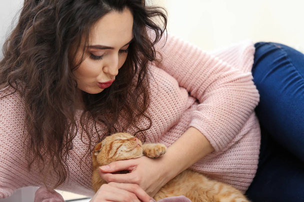 Young woman with cute funny cat at home - Fotoğraf, Görsel