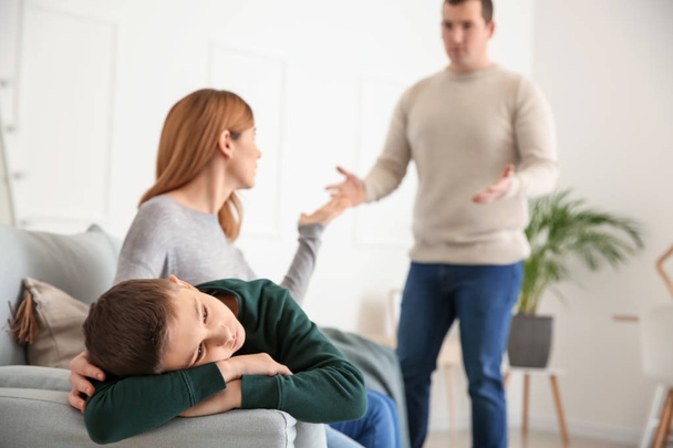Triste ragazzino con i suoi genitori litiganti a casa
 - Foto, immagini