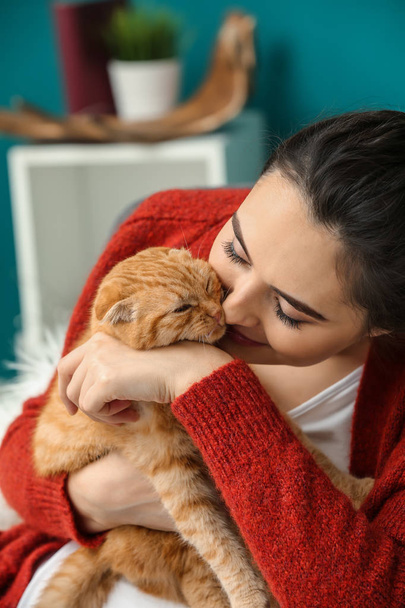 Молода жінка з милою смішною кішкою вдома
 - Фото, зображення