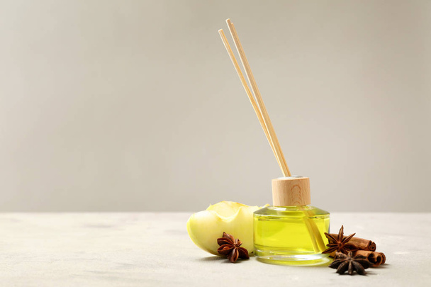 Reed diffuser, apple en specerijen op tafel - Foto, afbeelding