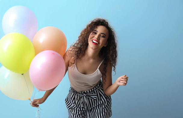 Beautiful young woman with balloons on light background - Foto, Imagem