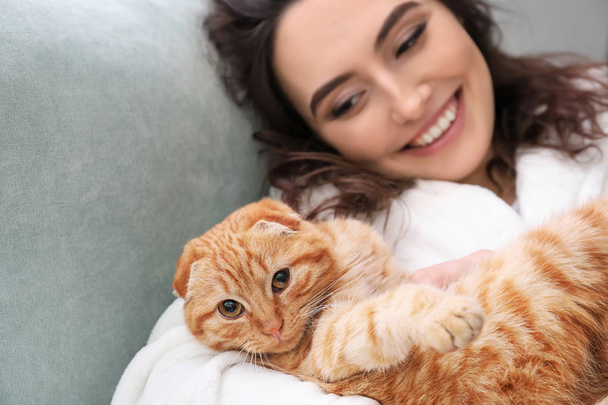 Jovem mulher com gato engraçado bonito em casa
 - Foto, Imagem