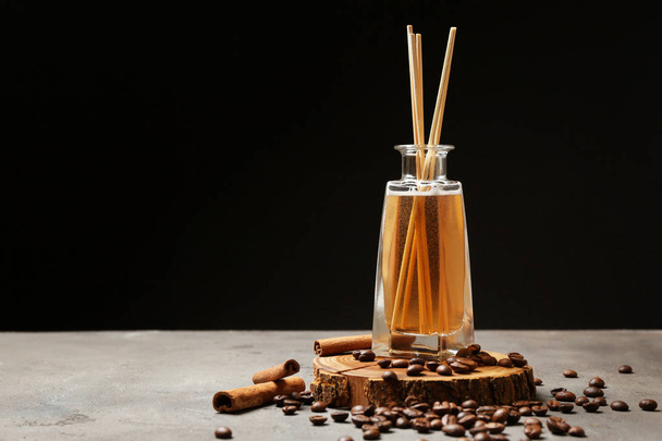 Difusor de junco, grãos de café e canela na mesa
 - Foto, Imagem