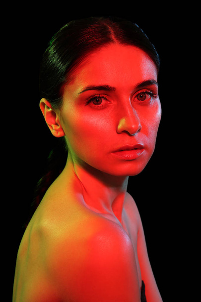 Toned portrait of beautiful young woman on dark background - Foto, Bild