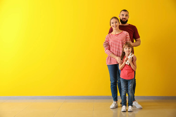 Ευτυχισμένη οικογένεια κοντά σε χρώμα τοίχου - Φωτογραφία, εικόνα