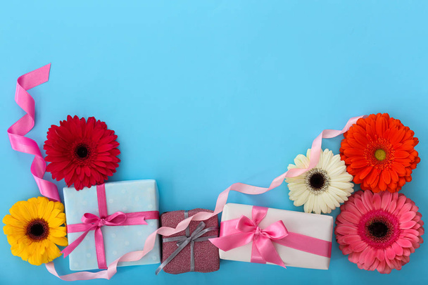 Lahjapakkaukset kauniita kukkia värillinen tausta. Iloisen äitienpäivän juhla
 - Valokuva, kuva