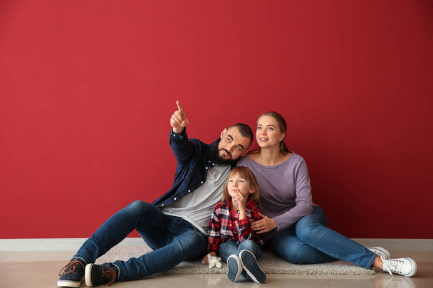 Glückliche Familie sitzt in ihrer neuen Wohnung auf dem Boden - Foto, Bild