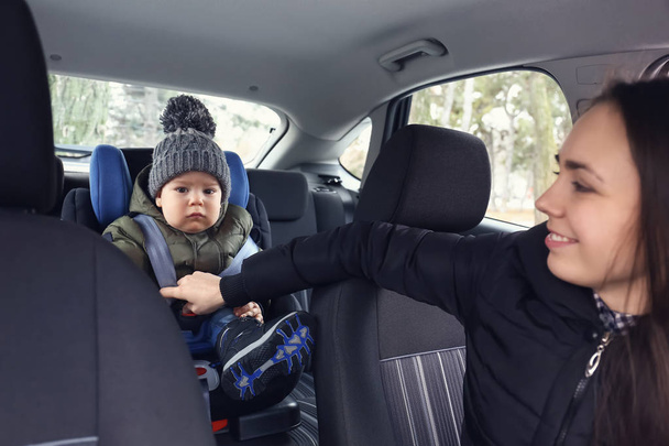 Jazda samochodem z synem kobieta zapięta w fotelik dla dziecka - Zdjęcie, obraz