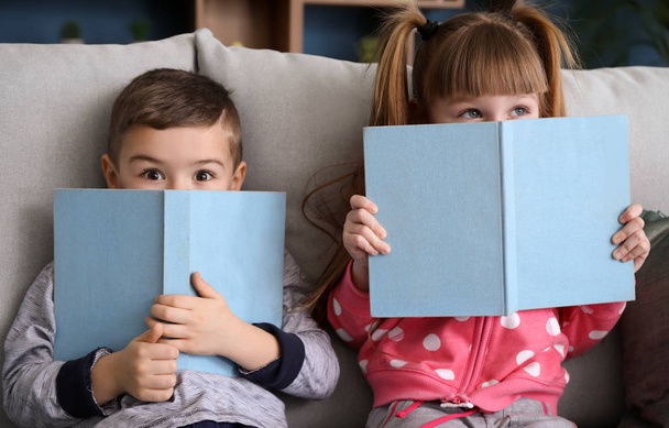 Χαριτωμένα παιδάκια διαβάζοντας βιβλία στο σπίτι - Φωτογραφία, εικόνα