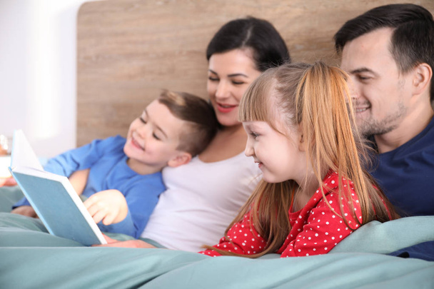 glückliche Familie liest Buch im Schlafzimmer - Foto, Bild