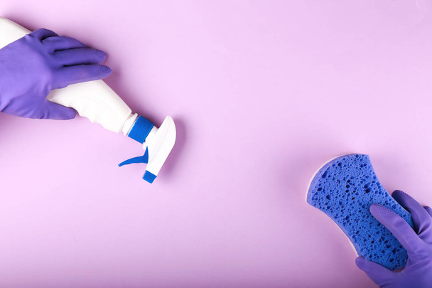 Hands of female janitor with sponge and detergent on color background - Foto, imagen