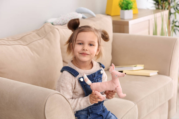 Portrait of cute little girl with toy at home - Photo, Image