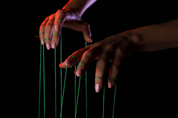 Hands of puppeteer on dark background - Photo, Image