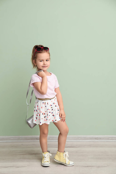 Portrait of cute little girl near color wall - 写真・画像
