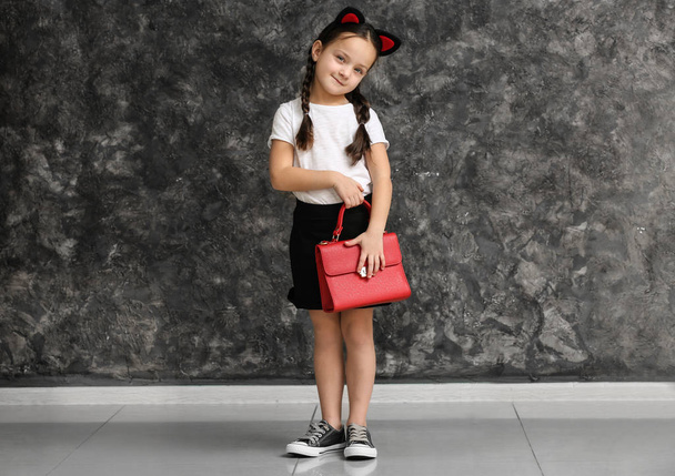 Портрет стильной маленькой девочки возле гранж-стены
 - Фото, изображение