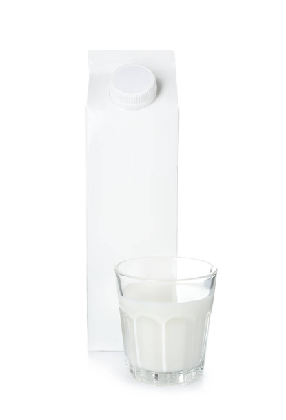 Bicchiere e pacchetto di gustoso latte fresco su sfondo bianco
 - Foto, immagini