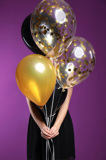 Beautiful young woman with balloons on color background - Фото, изображение