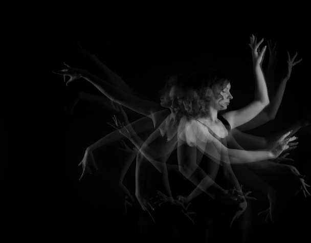 Stroboscopische foto van mooie bewegende jonge vrouw op donkere achtergrond - Foto, afbeelding
