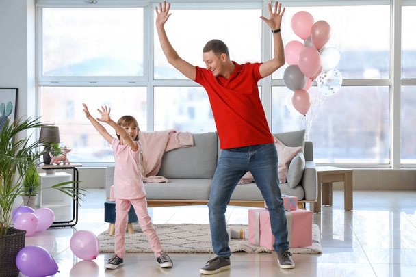Isä ja hänen söpö pieni tyttärensä tanssivat kotona.
 - Valokuva, kuva