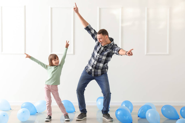 Ο πατέρας και η χαριτωμένη μικρή κόρη χορεύουν σε δωμάτιο με μπαλόνια - Φωτογραφία, εικόνα