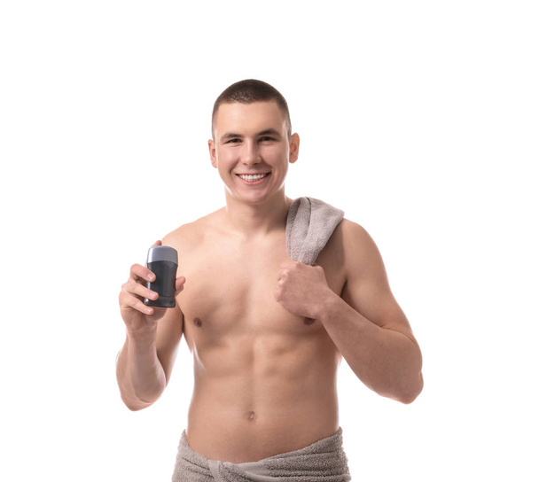 Handsome young man with deodorant on white background - Photo, Image